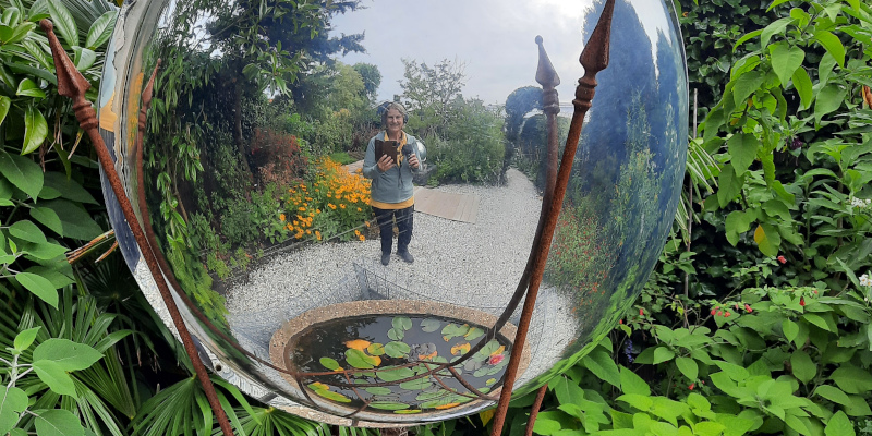 Tuin en podcaster gereflecteerd in bol